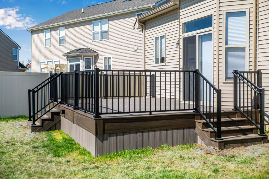 Outside view of a home with a new gray deck with black railings.
